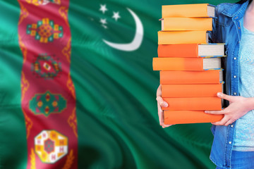 Turkmenistan national education concept. Close up of female student holding colorful books with...