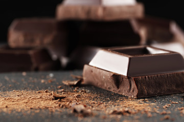 Chocolate bar pieces. Background with chocolate. Sweet food photo concept. The chunks of broken chocolate