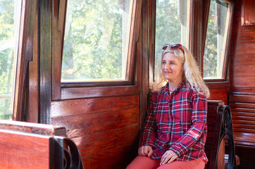 Obraz premium Woman dressed in a royal stewart red tartan shirt sitting in a vintage train - Sarganska 8