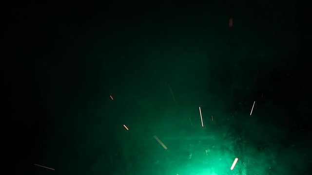 Green firework explding with sparks on the ground. Firework for kids. Slow motion