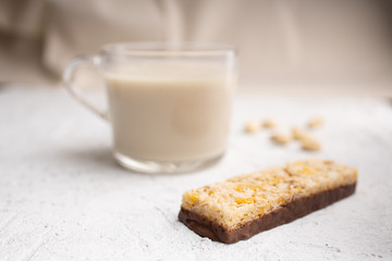 Healthy breakfast. Organic milk. Cereal granola bar. Glass cup with organic milk. Nut milk without lactose, gmo, antibiotics and casein. Diet food.  ..