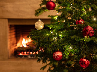 Christmas tree close up on burning fireplace background © Rawf8