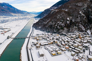 Valtellina (IT) - Panoramic aerial view of the Adda river and the Sirta village in winter