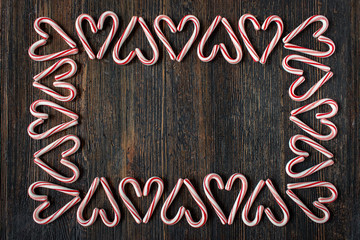alternating direction candy cane heart border with copy space on rustic wood table flat lay