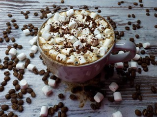  close-up of a hot drink, a cup of coffee / cocoa with marshmallows and chocolate chips on an abstract wooden surface background