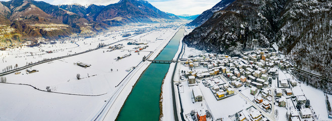 Valtellina (IT) - Panoramic aerial view of the Adda river and the Sirta village in winter