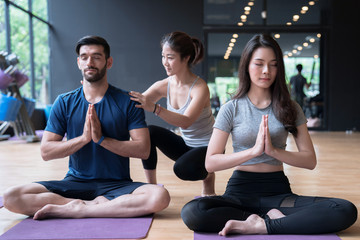 People who love health, exercise with yoga in the gym, with expert help.