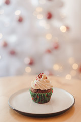 Close up party cupcakes with christmas tree shape on wooden table over golden bokeh. Christmas and new year holidays background concept.