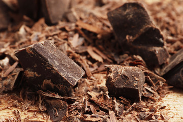 Different pieces of dark chocolate close-up. Top view. Place for text.