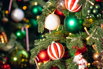 Christmas background tree branch with decorations candy lollipop cane red and green balls, with bokeh light