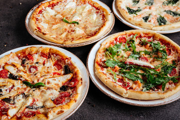 Traditional Italian pizza on a dark background top view copy space.