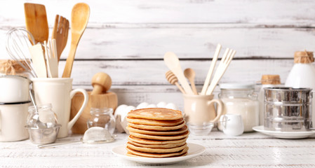 Fototapeta na wymiar Cooking pancakes. Ingredients, crockery and kitchenware for pancakes.