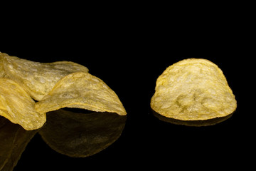 Lot of whole crisp potato chip isolated on black glass