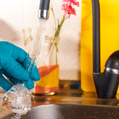 water purification specialist tap water pours into a glass flask.