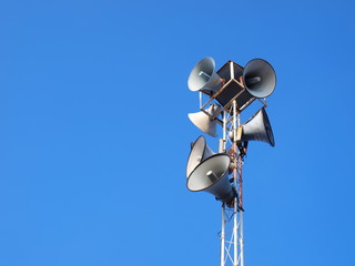 Many horn speakers on the tower On a clean blue sky background With copy space