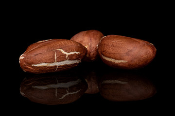 Group of three whole peeled tasty beige peanut isolated on black glass