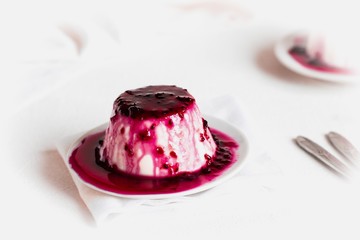 Creamy dessert Panna cotta, milk jelly with currant berry sauce