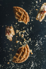 Flying broken butter cookies. Crushed cookie levitation. Food wallpaper. Vertical orientation