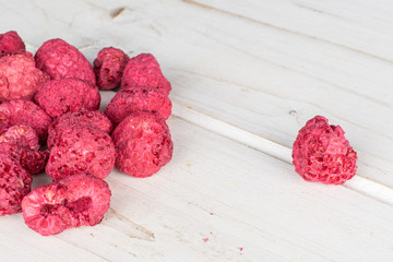 Lot of whole bright dried raspberry on white wood