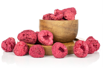 Lot of whole dried raspberry in bamboo bowl on round bamboo coaster isolated on white background