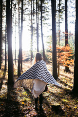 Young woman in a trench coat walks in autumn park