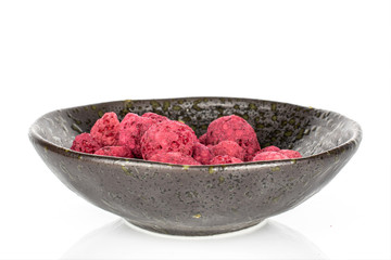 Lot of whole dried raspberry in glazed bowl isolated on white background