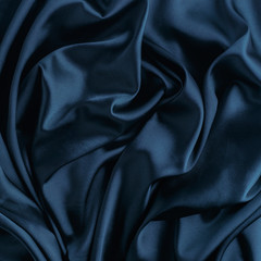 Wavy blue silk, atlas or veil fabric, crumpled with creases, bended in spiral wrinkle