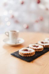 Italian coffee small Cup and cookie on the table near the Christmas tree with golden bokeh