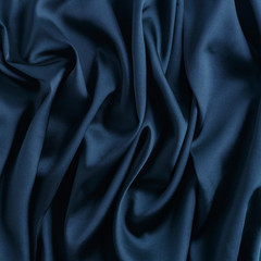 Wavy blue silk, atlas or veil fabric, crumpled with creases, bended in spiral wrinkle