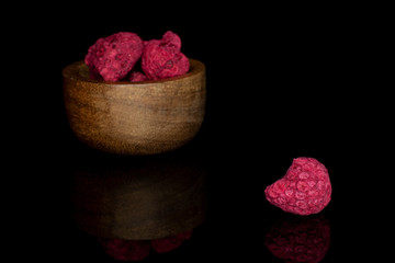 Lot of whole dried raspberry in bamboo bowl isolated on black glass