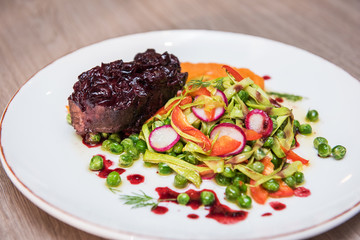 Roasted beef with berries sauce garnished with vegetables