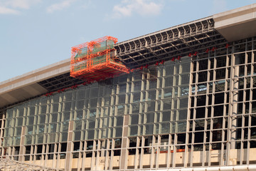 scissor elevated lift platform. Multi-storey with many glass Windows .background of glass windows of modern office building .construction glass curtain-wall facade .New Head railway in Bangkok