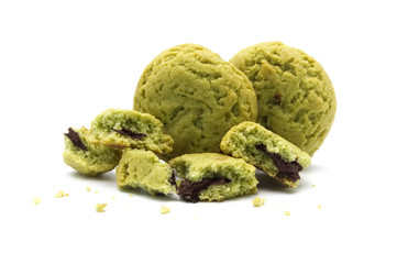 Fototapeta premium Crumbs of soft cookies green tea flavored filled with chocolate cream on white background.