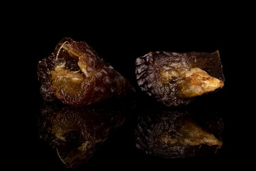 Group of two halves of dried brown date fruit isolated on black glass