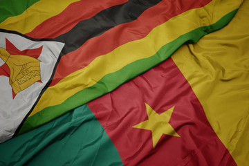 waving colorful flag of cameroon and national flag of zimbabwe.