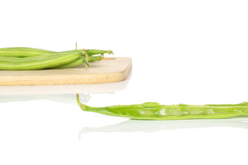 Lot of whole one half of snap green bean on bamboo cutting board isolated on white background