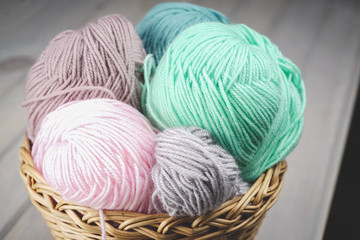 Fototapeta na wymiar Balls of yarn for knitting. Balls of yarn for knitting in a wicker basket. Knitting thread. Colorful threads.