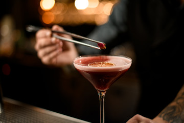Close-up of bartender adding flower in cocktail