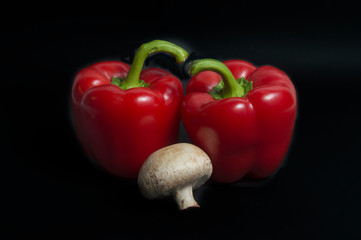 Red peppers and mushroom isolated on black background