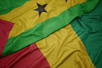 waving colorful flag of guinea and national flag of sao tome and principe .