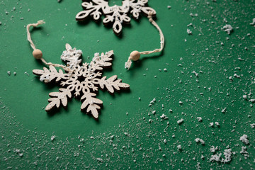 White snowflake on green snow background, holiday concept