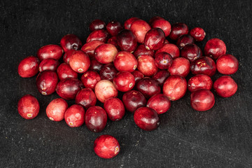 Lot of whole fresh red cranberry on grey stone