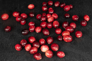 Lot of whole fresh red cranberry on grey stone