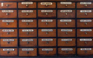 Many wooden boxes with latin inscriptions of names of medicines in old pharmacy