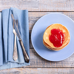 Tasty breakfast. Pancakes with strawberry confiture and butter.