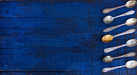 Vintage cutlery - spoons, forks and knives on an old wooden background.