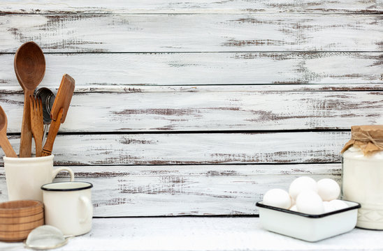 Vintage old baking utensils on a white wooden background.
