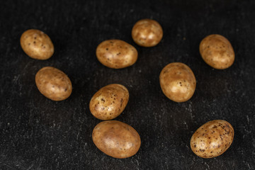 Fototapeta na wymiar Lot of whole tiramisu brown almond nut on grey stone