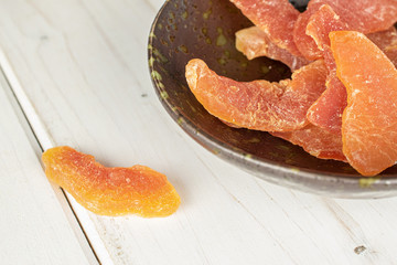 Lot of whole dried orange papaya piece in glazed bowl on white wood