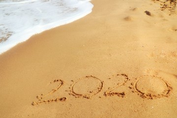 Happy New year 2020 with the waves beat at the beach and shell fragments. Soft focus. Holiday and nature concept.